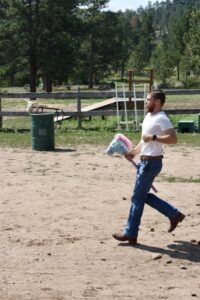 wrangler at the ranch riding a stick horse