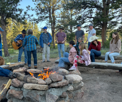 ranch guests enjoying cowboy singing around the campfire