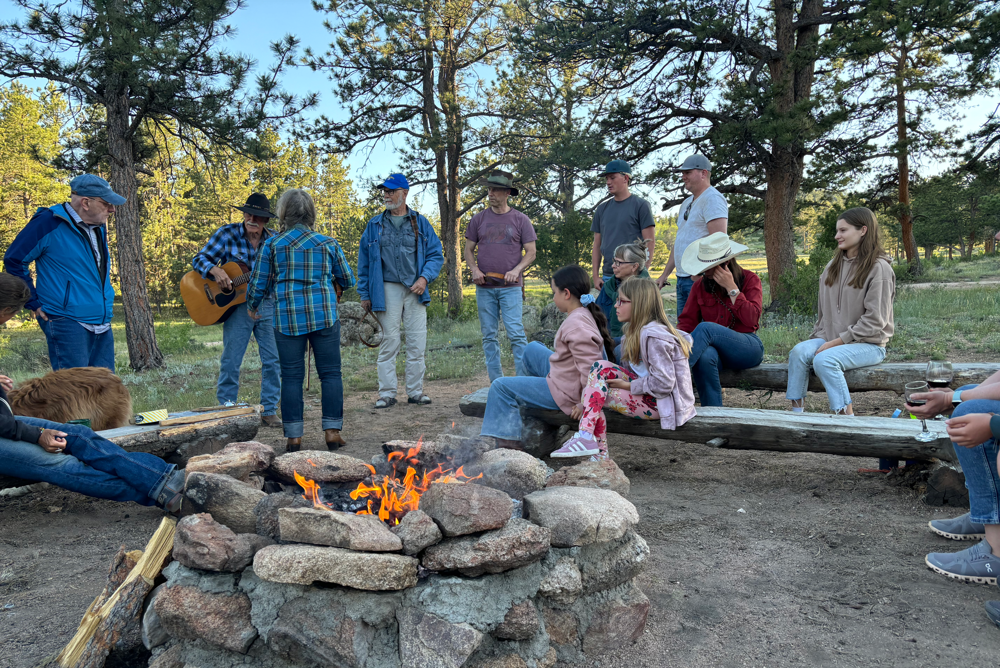 ranch guests enjoying cowboy singing around the campfire