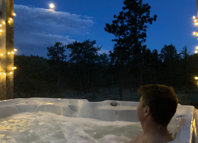 man in hot tub with moon overlooking