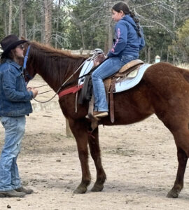 wrangler teaching young girl how to be safe on her horse