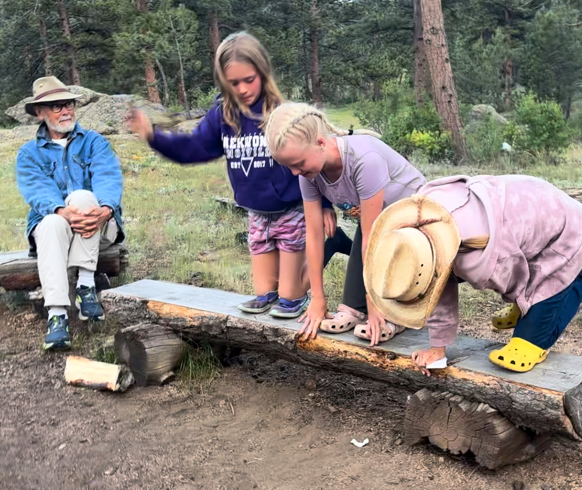 Grandpa watches his granddaughters having fun at the ranch